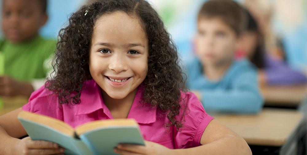 Photo of child smiling with book